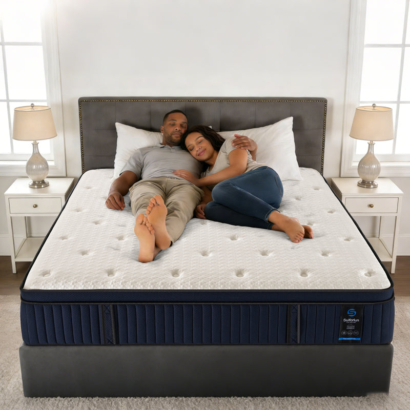 Couple lying on a mattress in a bedroom setting with nightstands and lamps.