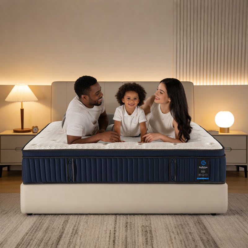 Family sitting on a mattress in a bedroom setting