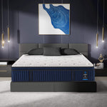 Blue and white mattress on a bed in a modern bedroom with abstract art and pendant lights.